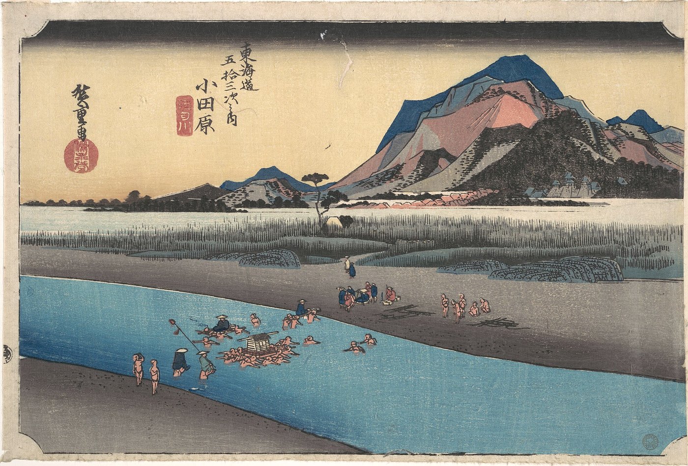 歌川広重『東海道五十三次之内 小田原 酒匂川』。人足に担がれて酒匂川を渡る旅人と、遠くの小田原城
